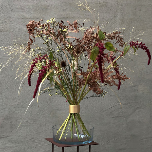 Herbstliches Ikebana-Display mit roten Amaranthen und Farnen, kunstvoll gesichert durch einen Hanataba-Spiralstängelhalter.