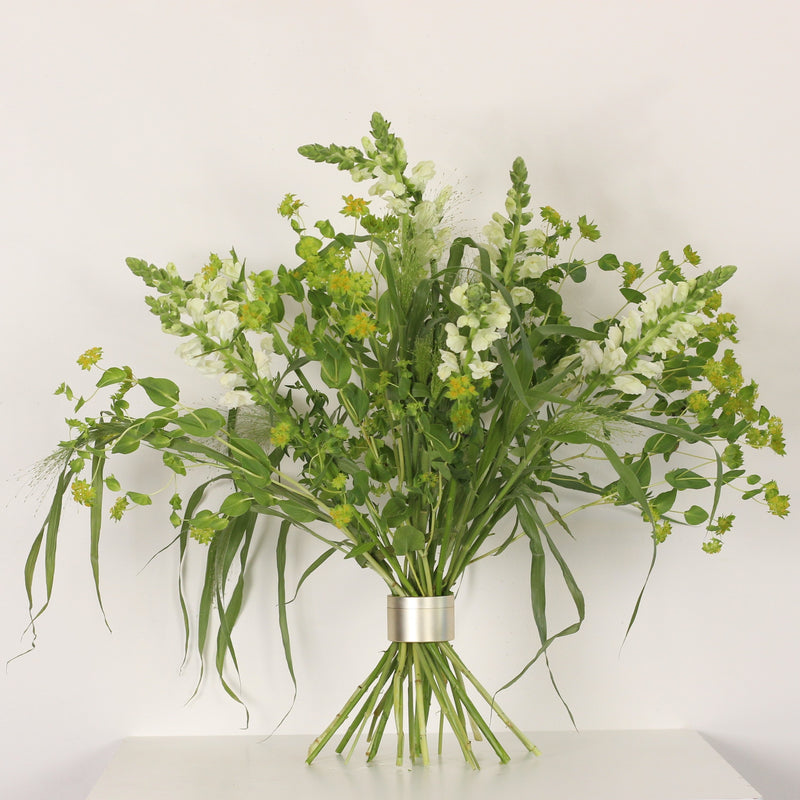 Ein Ikebana-inspiriertes Blumenarrangement in voller Blüte, gesichert durch einen Bouquet Twister, der eine Harmonie aus weißen und gelben Blumen zeigt